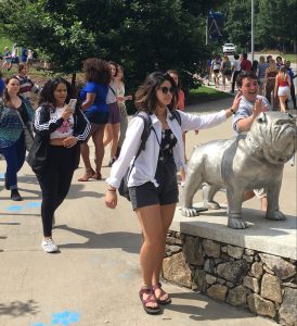 Students pat the Rocky bulldog statue as the walk in to Convocation