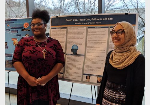 two students display their research poster
