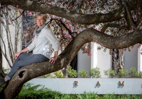 Alli Marshall poses on a tree branch outside of Ramsey Library