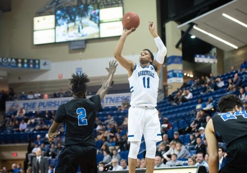 A UNC Asheville basketball player shooting the ball