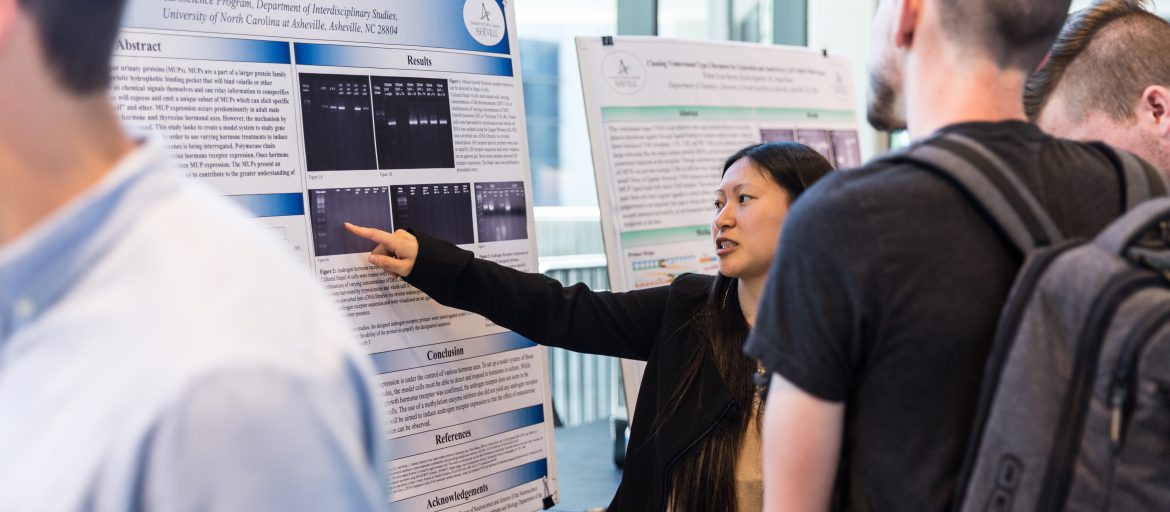 Student at Undergraduate Research Symposium with her poster presentation