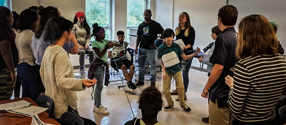 College students and middle school students play a group game.