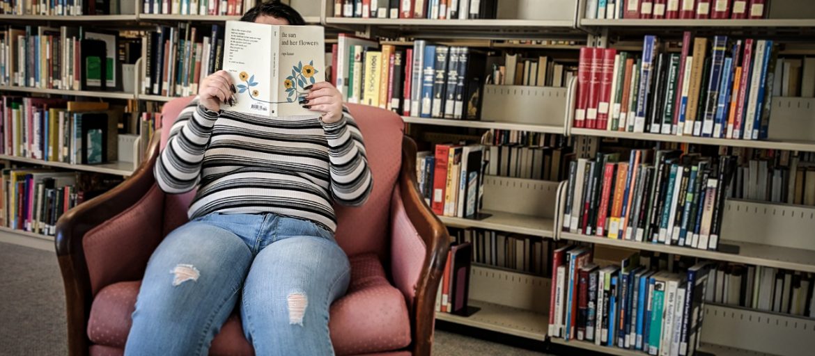 A student reading a book in UNC Asheville's Ramsey Library