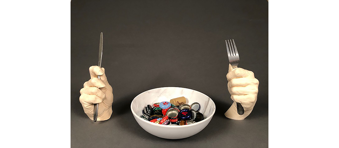 Nikas, Alex – Ben’s Friends web two scuplted hands hold fork and knife, with a bowl of bottle caps between them