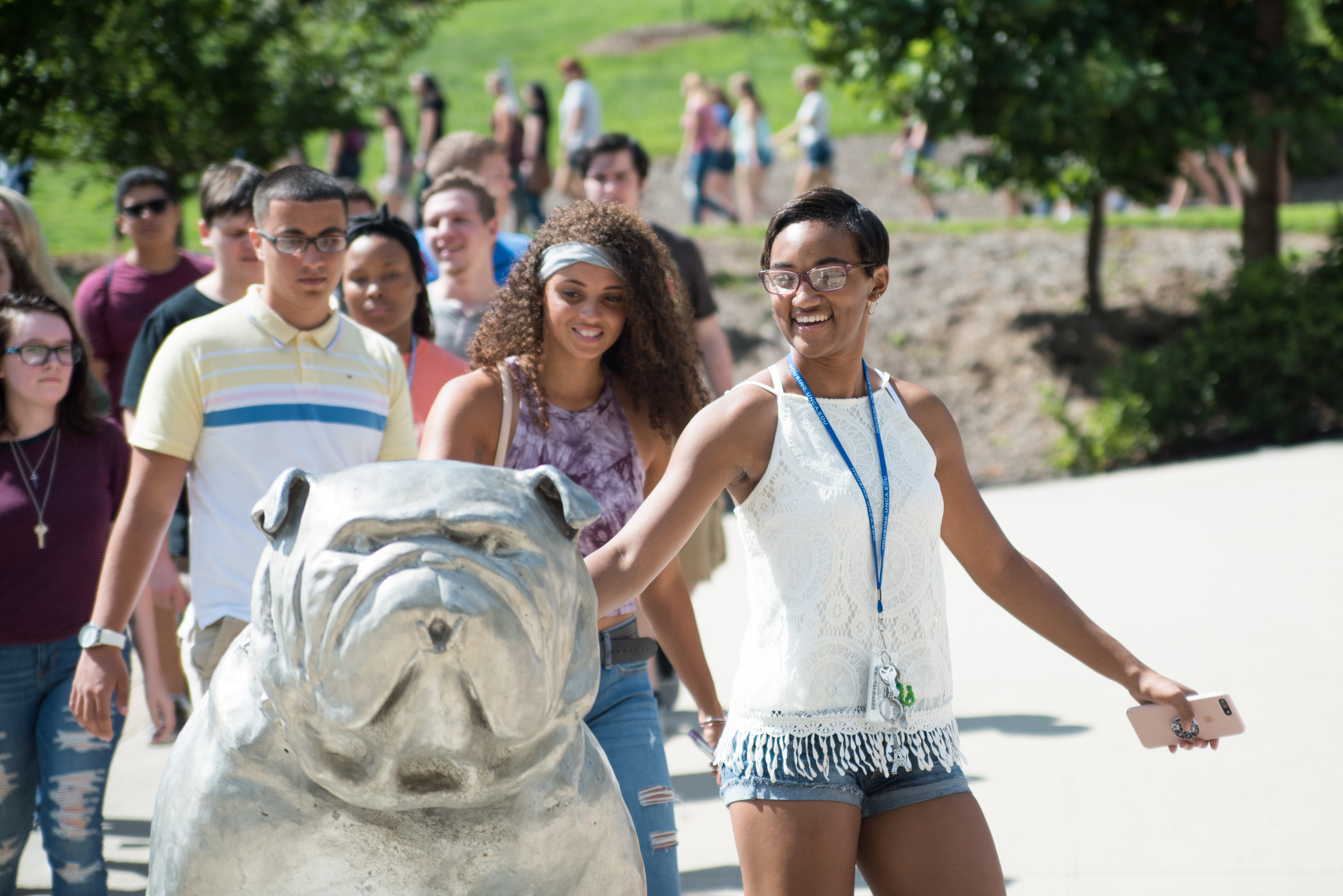 Convocation 2017-8 (1) Student patting Rocky the Bulldog statue