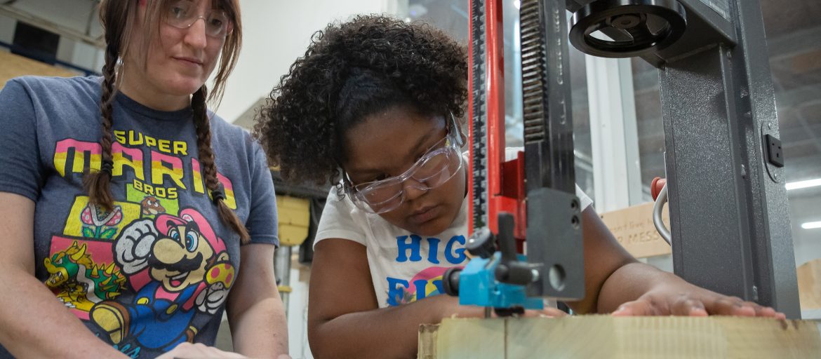 two young women operating a saw