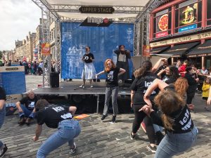Student performers on a makeshift stage in the street