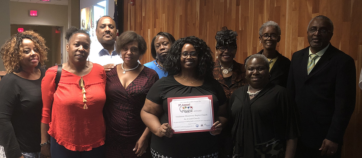 Members of the church pose with a PRAISE certificate