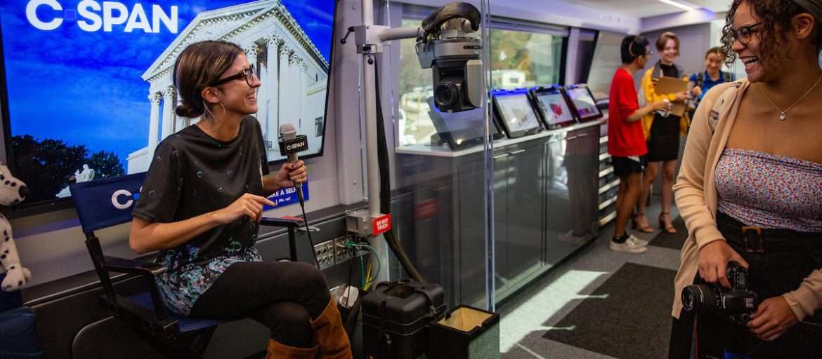 two girls laughing with a mic and a camera