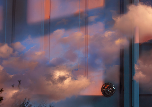 photo has sky superimposed over view of door and wall