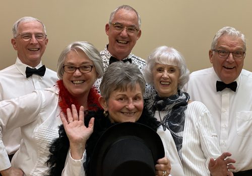 Six members of the Reuter Center Singers pose in formal attire with cheery smiles