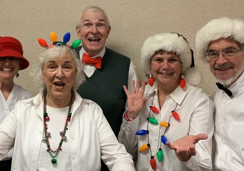 Members of the choir pose with Santa hats and holiday garb