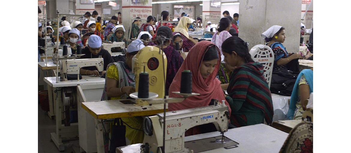 TrueCost_FilmStill_15 Crowded room full of people at sewing machines, many wearing face masks
