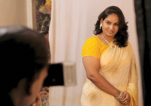 Image from the film shows woman in traditional Indian sari with a man looking at her