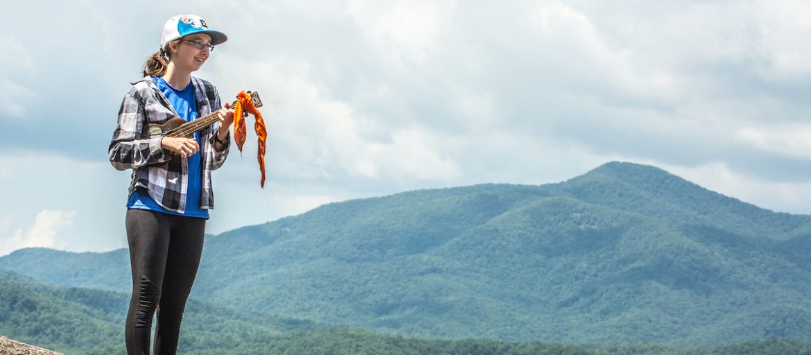 a student plays ukulele on a mountain