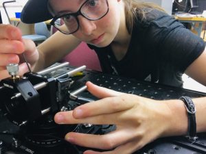 Samantha Creech adjusts the beam collimator, one of the components of her laboratory setup.