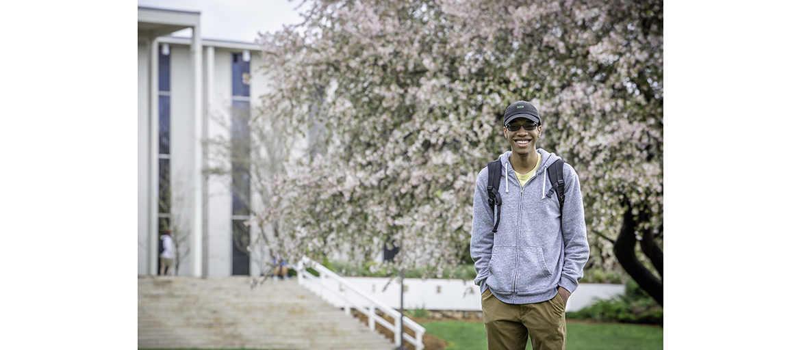 Isaiah Green stands on the university quad