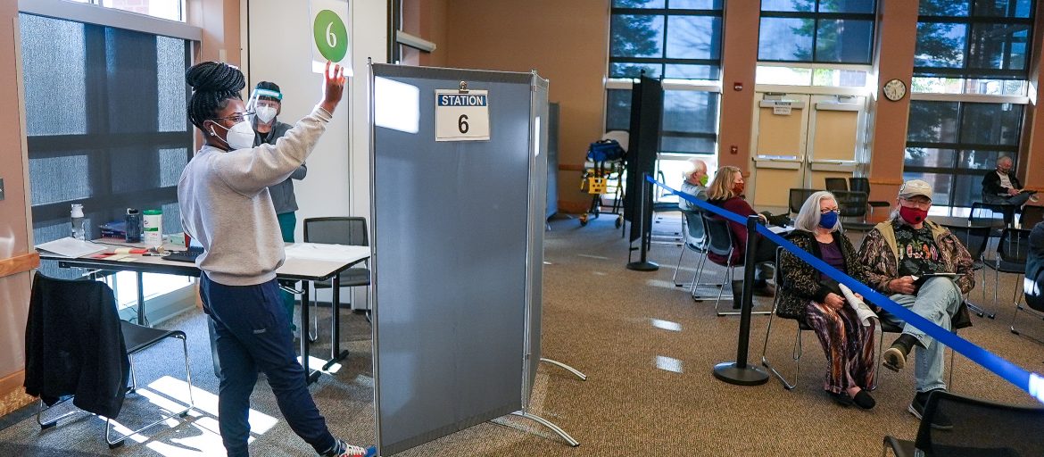 a woman at a vaccine clinic calls for the next person