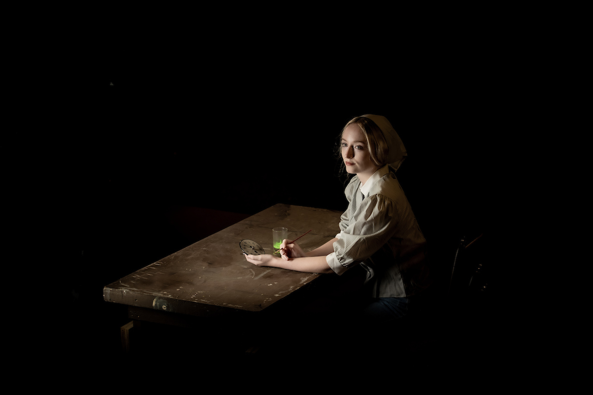 RadiumGirls- Girl sitting at a table painting a clock