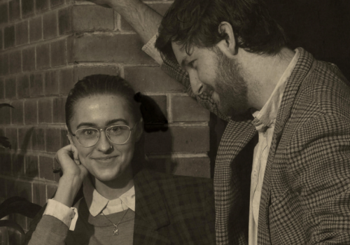 Old timey photograph of a man staring at a woman, and the woman staring at the camera