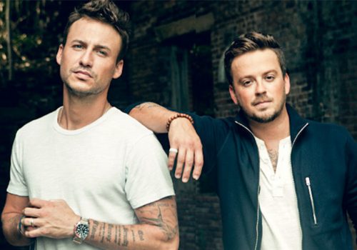 two young white men, likely musicians, actively not smiling