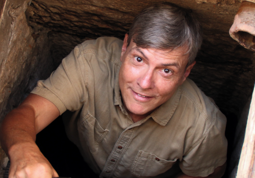 top down photo of a man climbing out of a hole in the ground