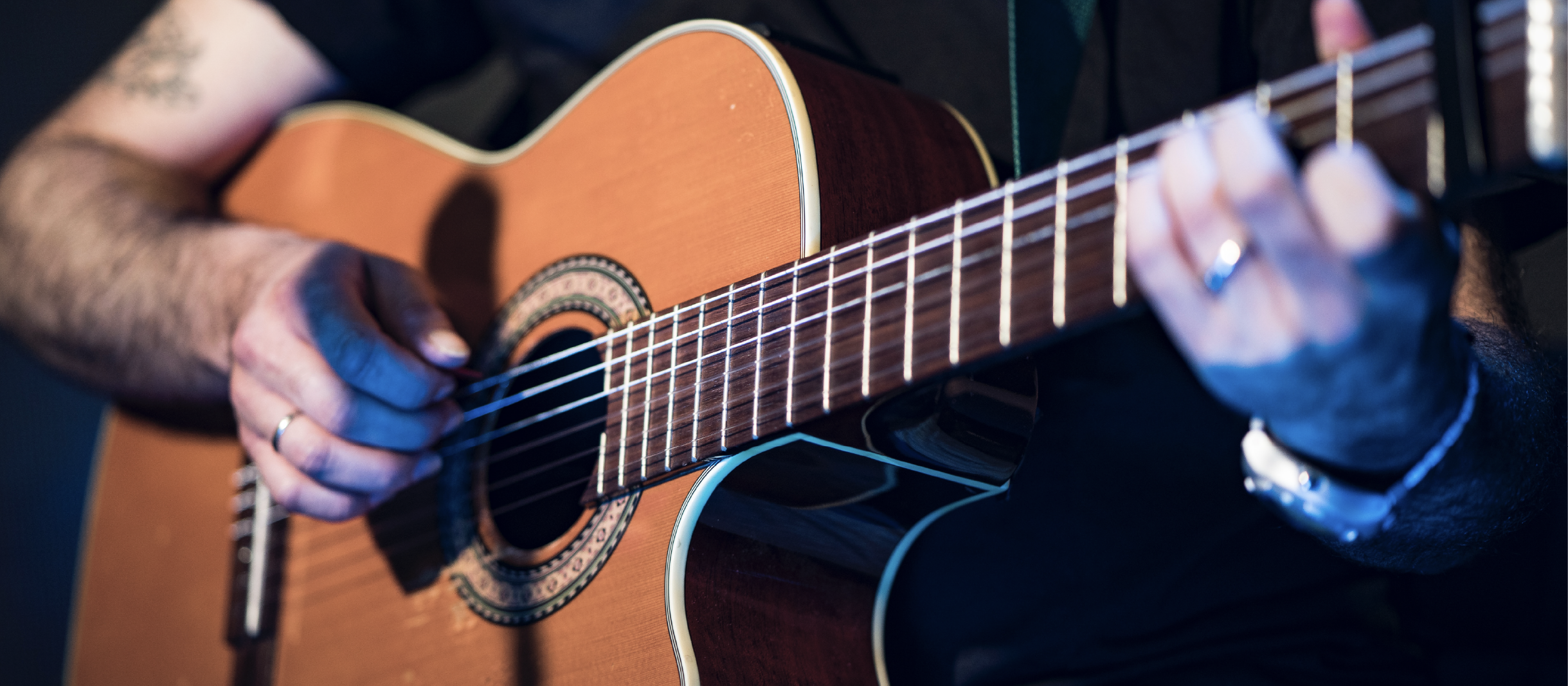 092022_facultyshowcase_event-post_1170x512 Close up of a guitar being played
