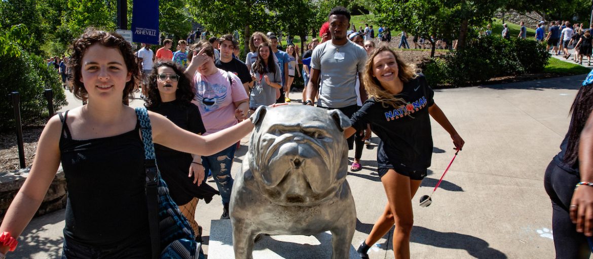 A crowd of Incoming students doing the tradition of petting the Rocky Statue during convocation