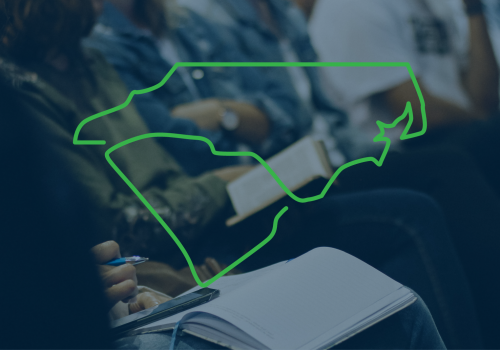 image of people sitting in an auditorium. The outlines of the states of North and South Carolina overlaid on top of the photo