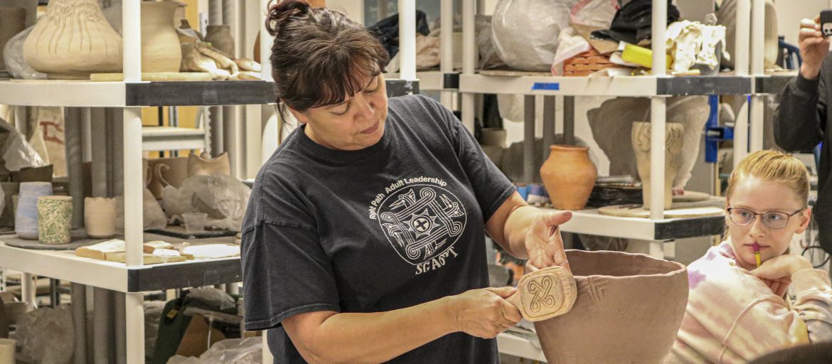 Tara McCoy, Cherokee ceramicist and NEA endowed artist, demonstrates shaping pottery using Cherokee tools and techniques with a class of UNC Asheville students.