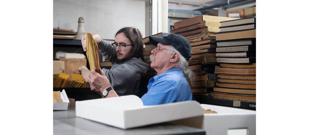 Gene Hyde, head of special collections at UNC Asheville's Ramsey Library, goes through folders of photographs with help from UNC Asheville student Michael Dennis, January 29, 2024. Photo courtesy of Angela Wilhelm/Asheville Citizen Times