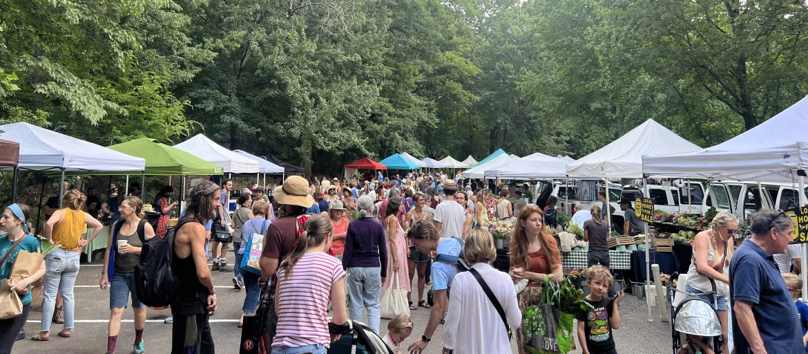 The North Asheville Tailgate market full of farmers booths and patrons.