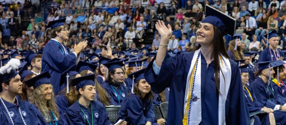 A student waves to family at Commencement.