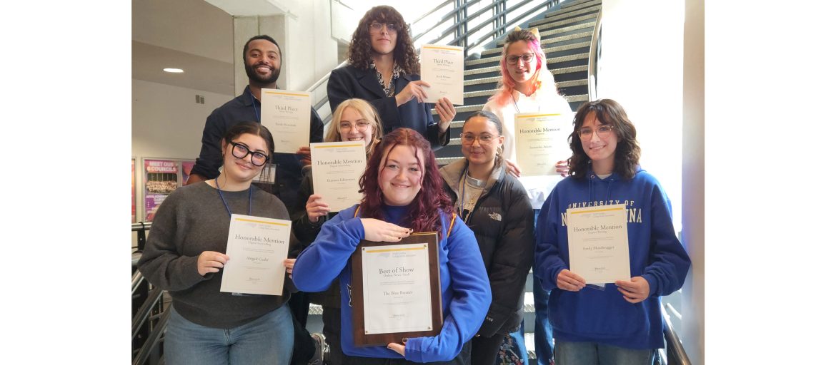 a photo of students holding awards