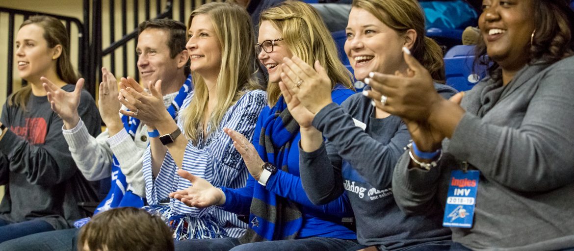 People cheer at a basketball game.