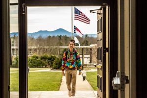 Student walking into Ramsey Library with mountains in the background