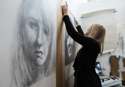 Art student Kristen Sorensen hangs a self portrait in her studio