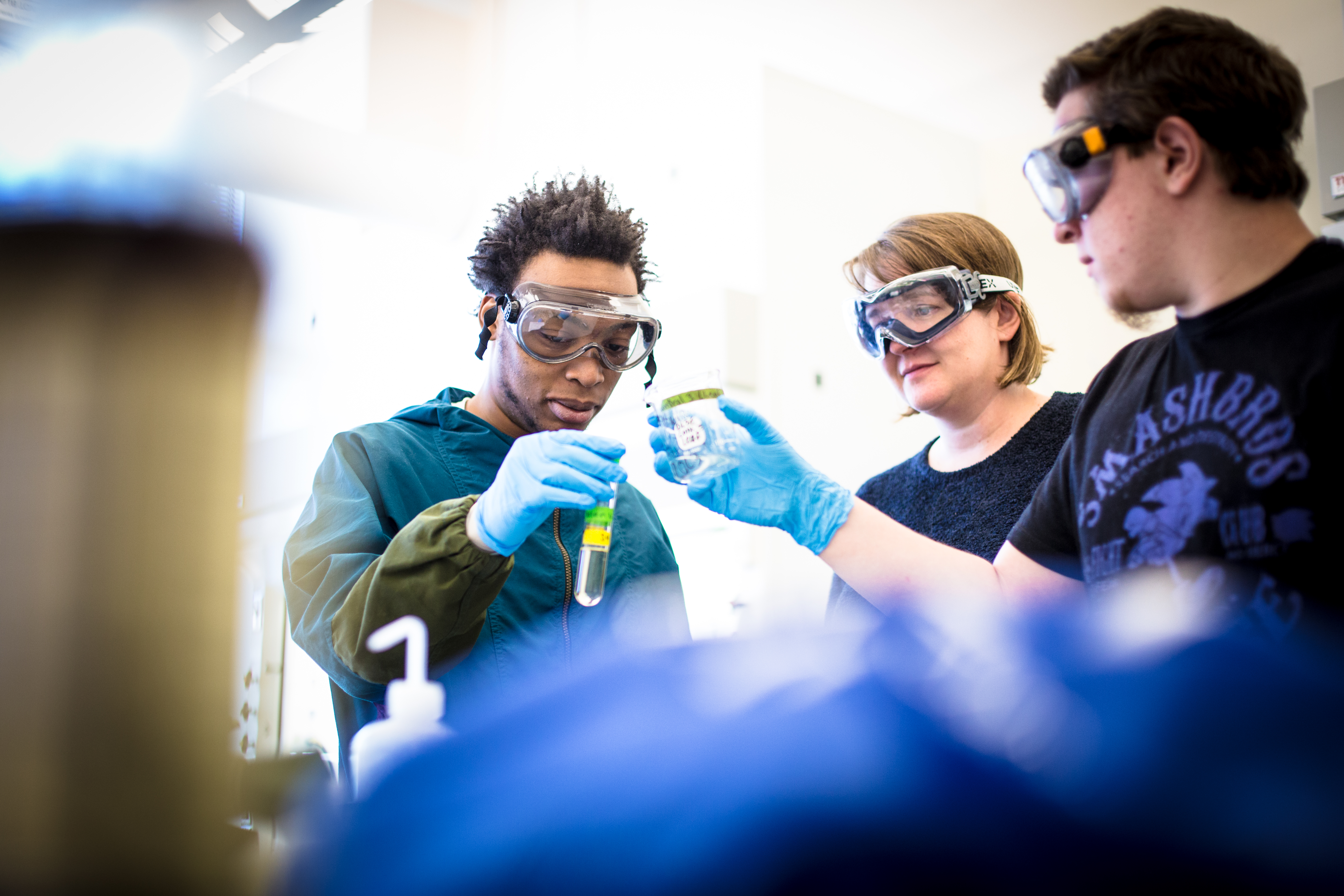 Two Students and a professor in the chemistry lab.