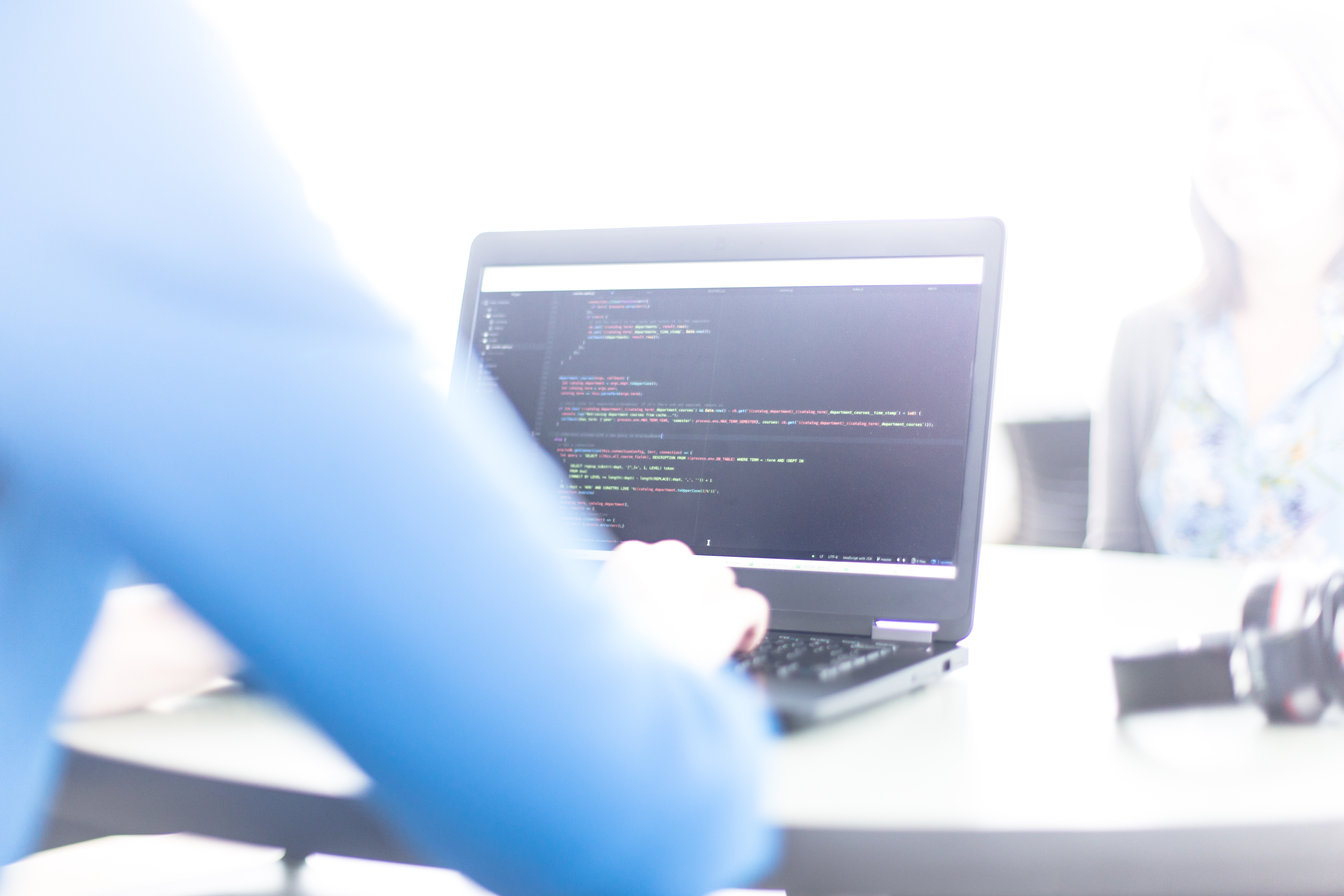 Close-up of a student writing code on a laptop.