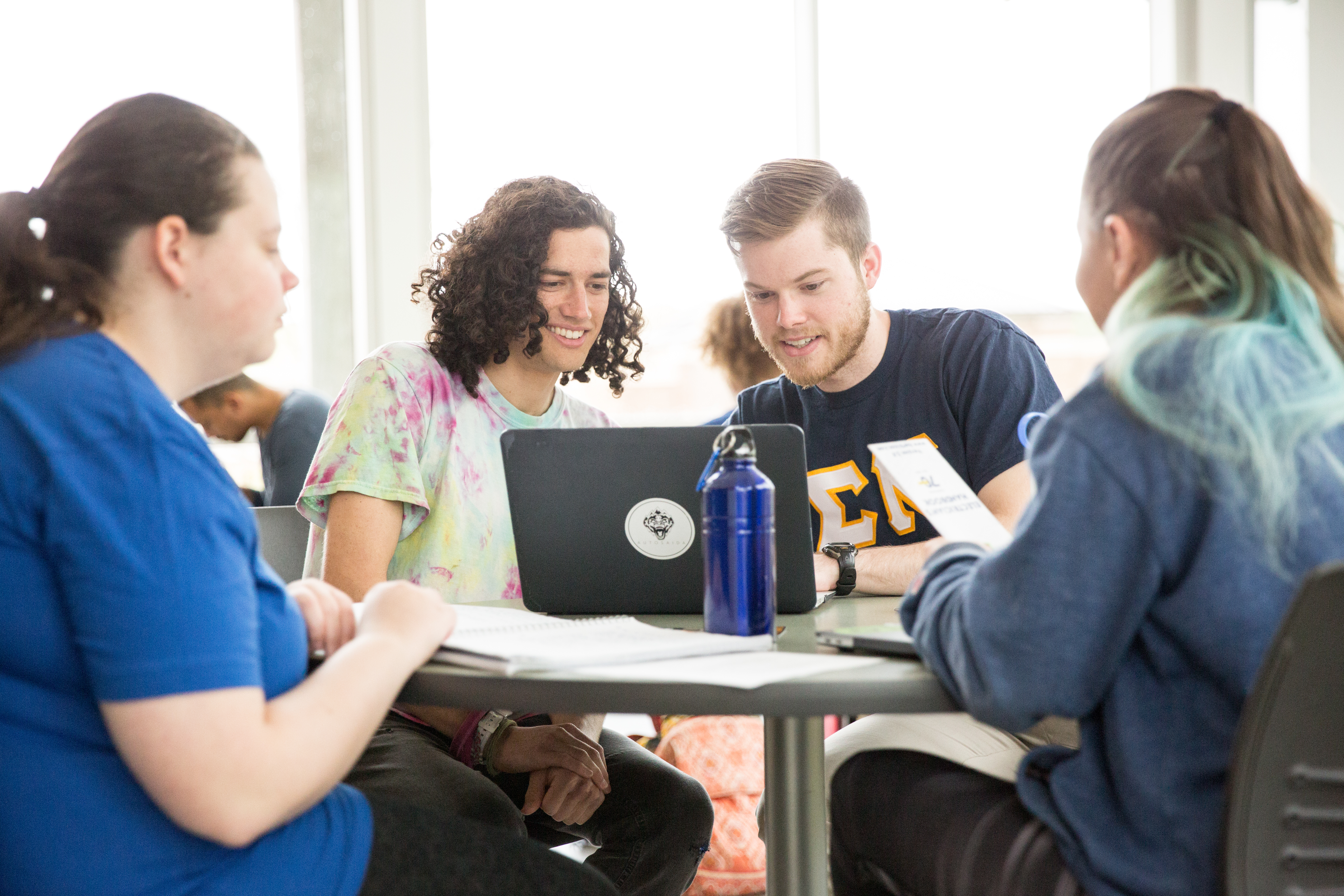 Students sitting at table in atrium in Rhoades-Robinson Hall