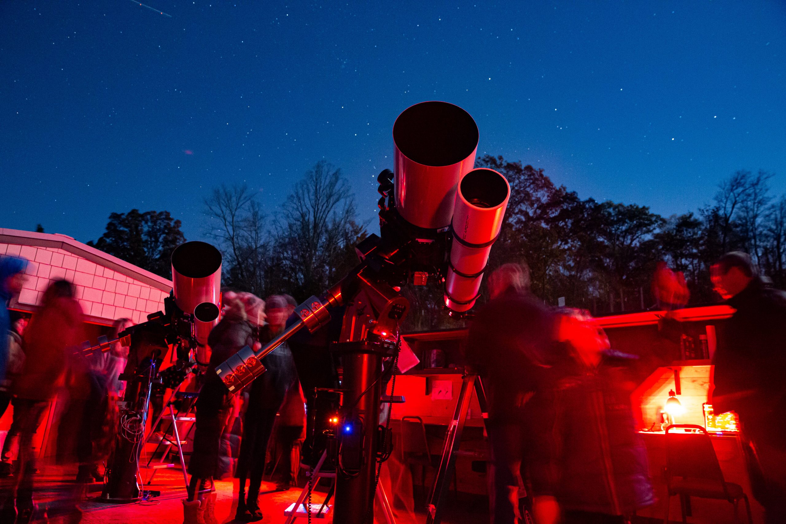 People at the Lookout Observatory telescopes at night