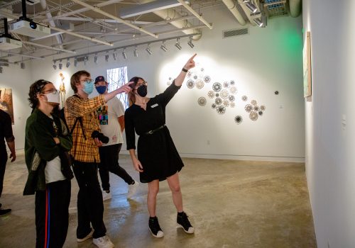Professor Ashe showing students her art in the New Media gallery