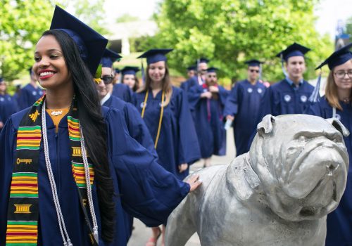 Graduate patting Rocky statue