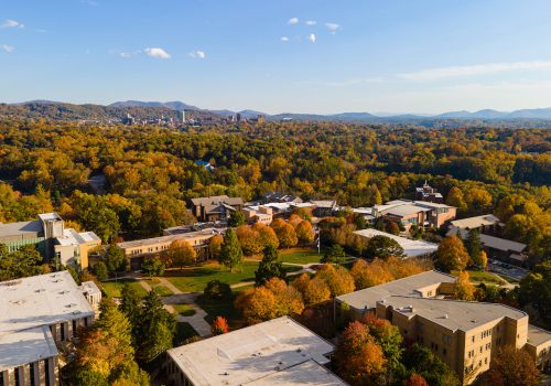 Drone photo of UNC Asheville Campus, downtown Asheville and the Blue Ridge Mountains in the background
