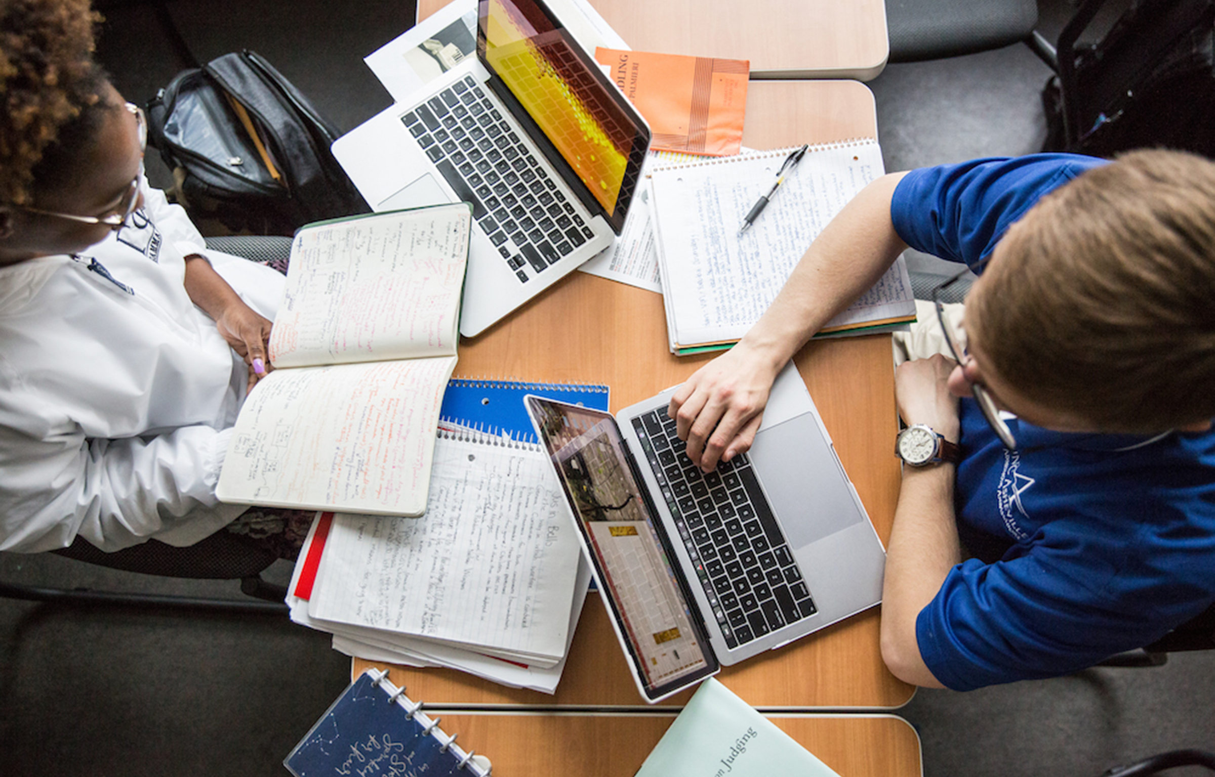 Students studying with computers and books