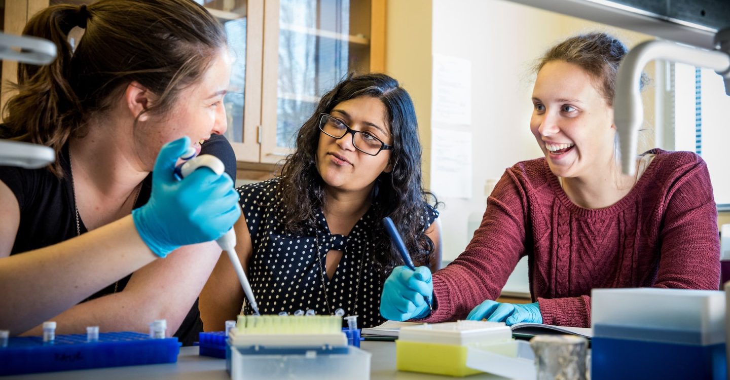 a professor and two students working in a biology lab